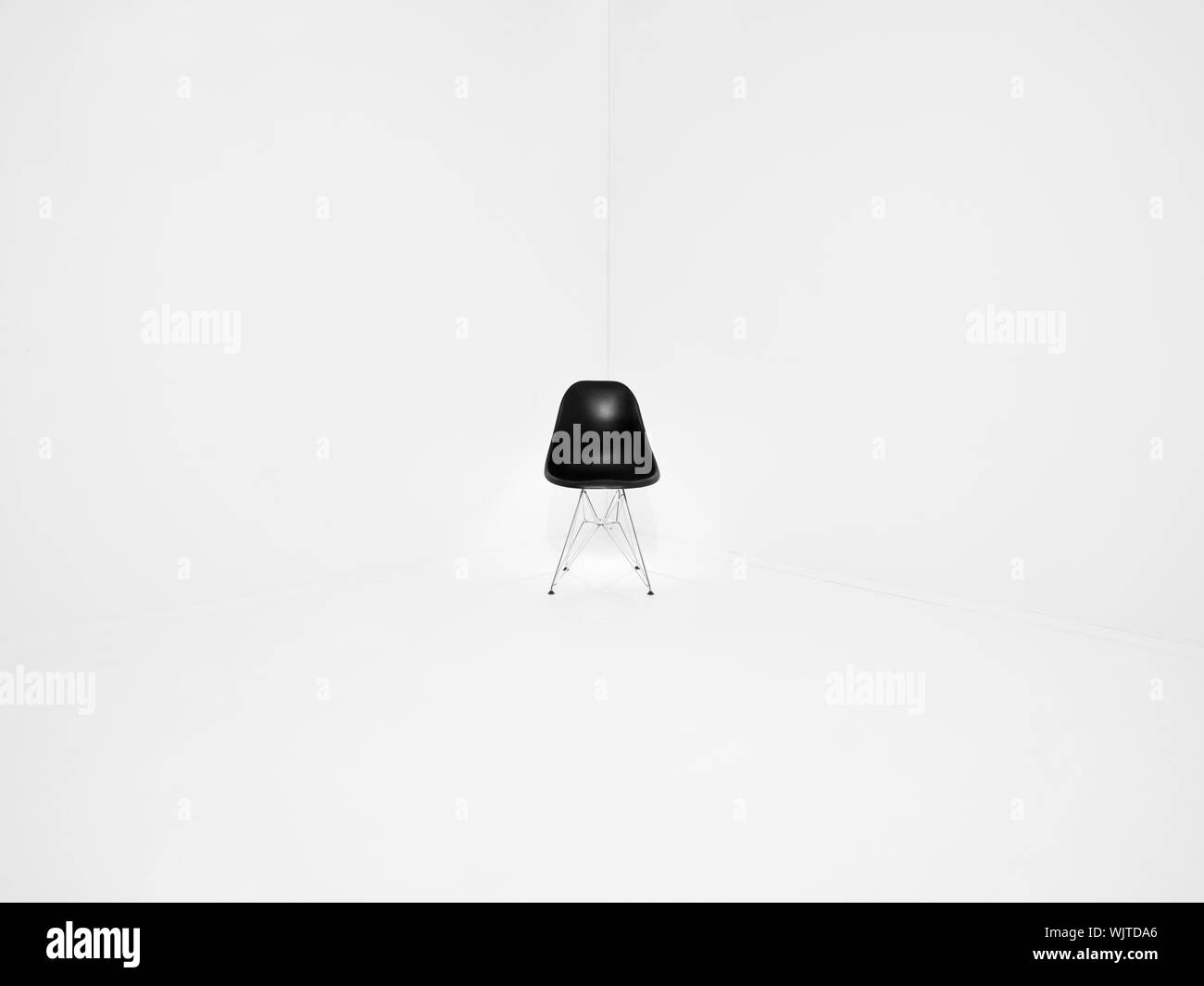 Chaise rétro dans un coin d'une salle blanche Banque D'Images