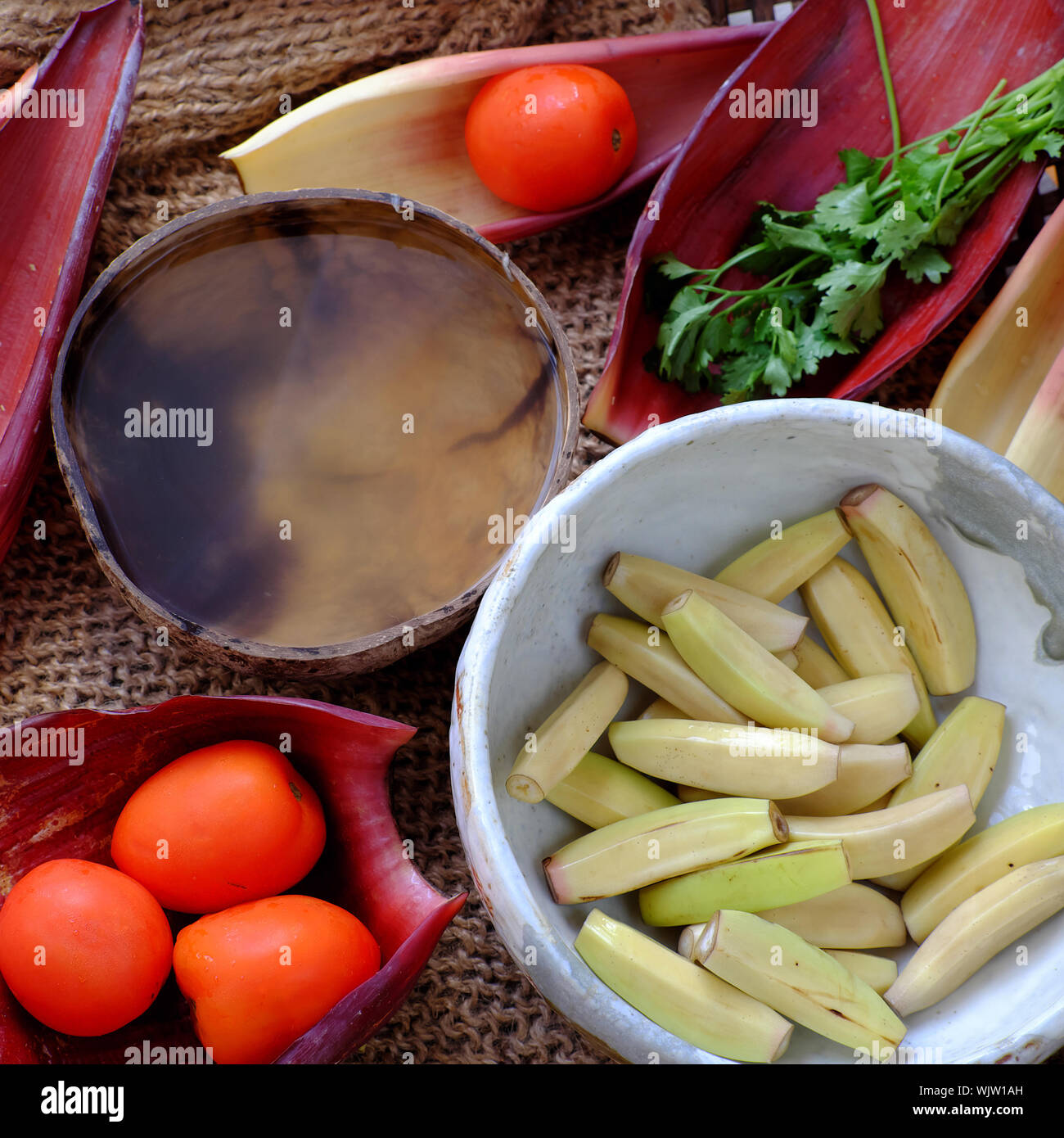 Ingrédients pour la nourriture végétarienne vietnamienne fait maison, fleur de bananier poisson vegan cook avec la sauce de soja, noix de coco et tomate, plat délicieux banane blossom Banque D'Images