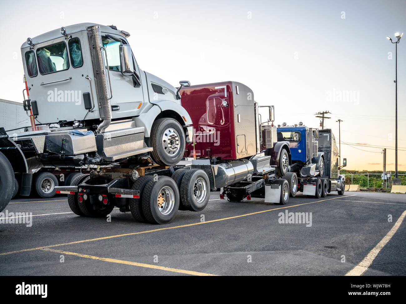 Gros camion puissant noir semi truck camions semi nouveau transporte les tracteurs attelés les uns sur les autres pour former un train routier debout sur l'arrêt de camion pa Banque D'Images