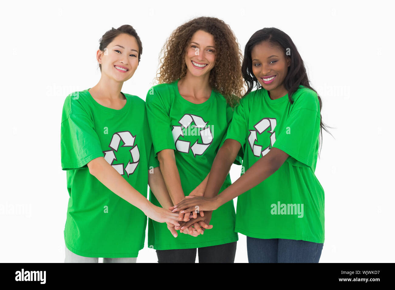 Équipe de militants environnementaux smiling at camera avec les mains ensemble sur fond blanc Banque D'Images