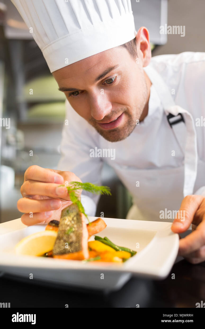 Libre d'une male chef de garnir la nourriture dans la cuisine Banque D'Images