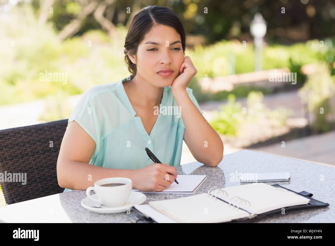 De graves businesswoman having coffee et de planification dans la semaine avec patio du restaurant Banque D'Images