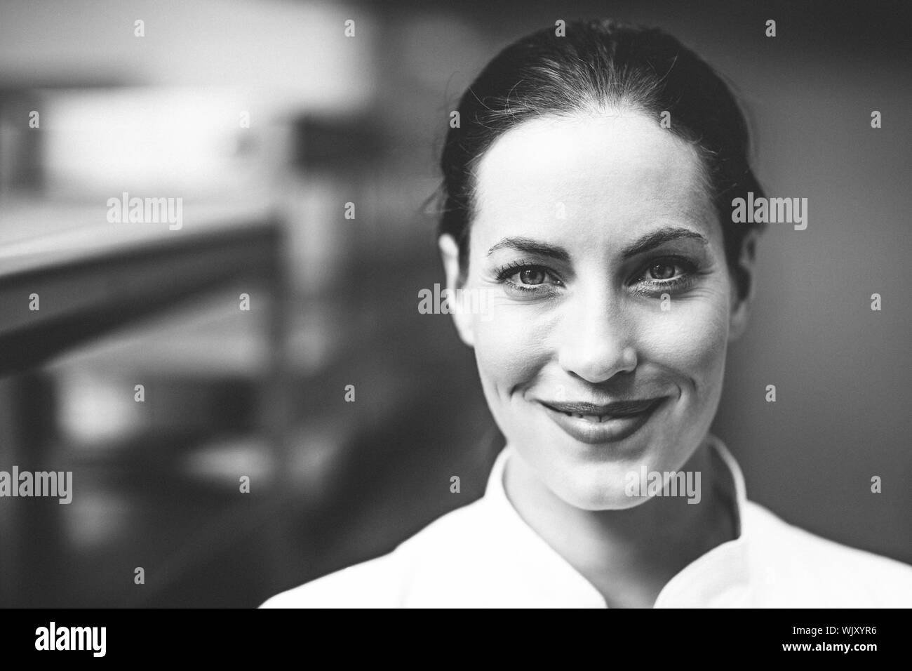 Happy chef smiling at camera dans une cuisine commerciale Banque D'Images
