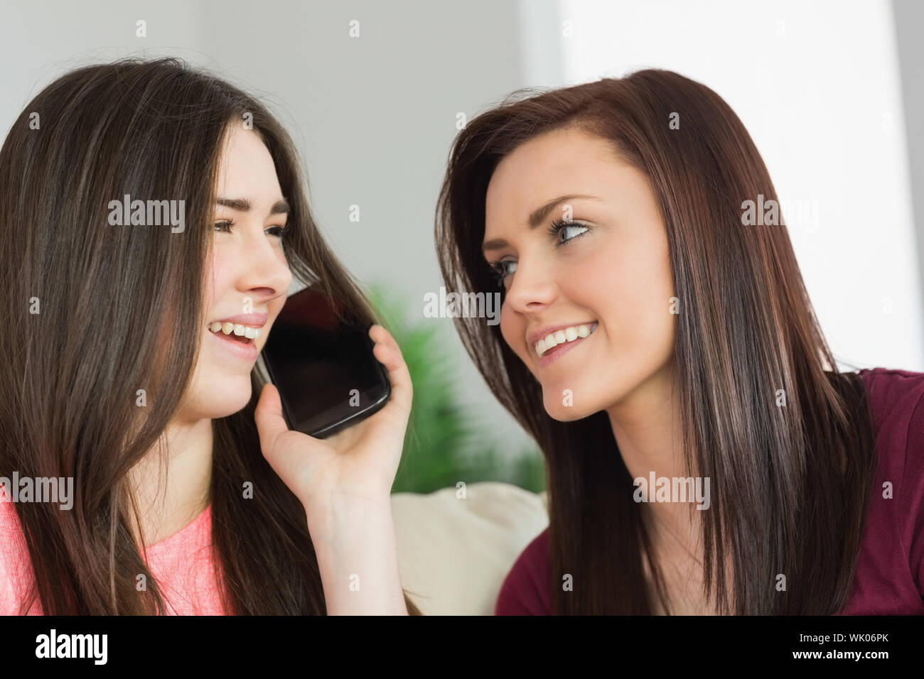 Deux heureux pour appeler quelqu'un avec un téléphone mobile Banque D'Images