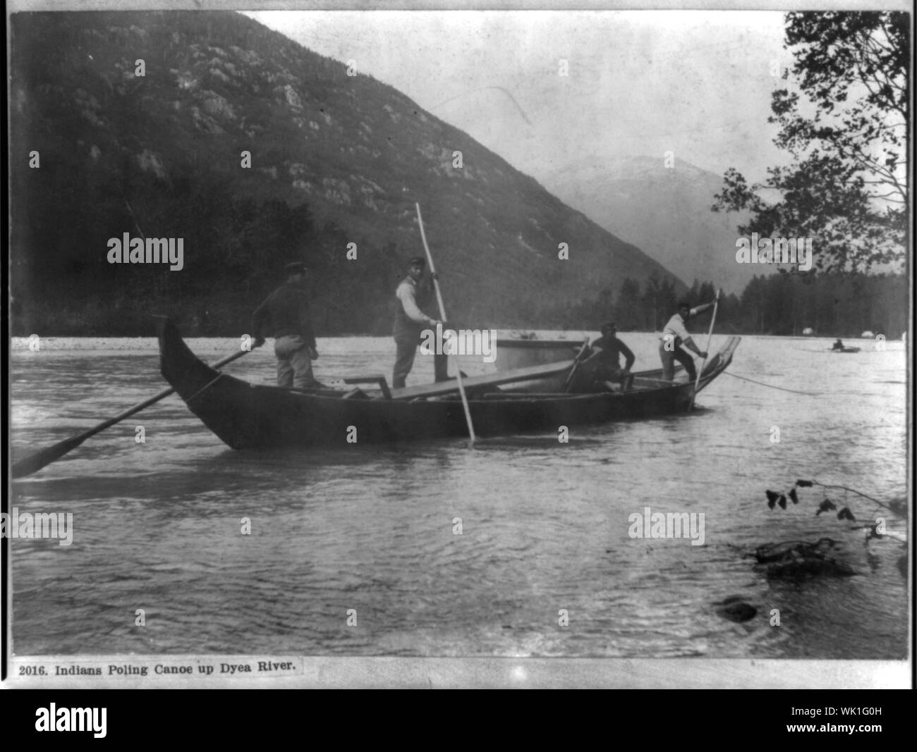 Poling indiens jusqu'en canot la rivière Dyea Banque D'Images