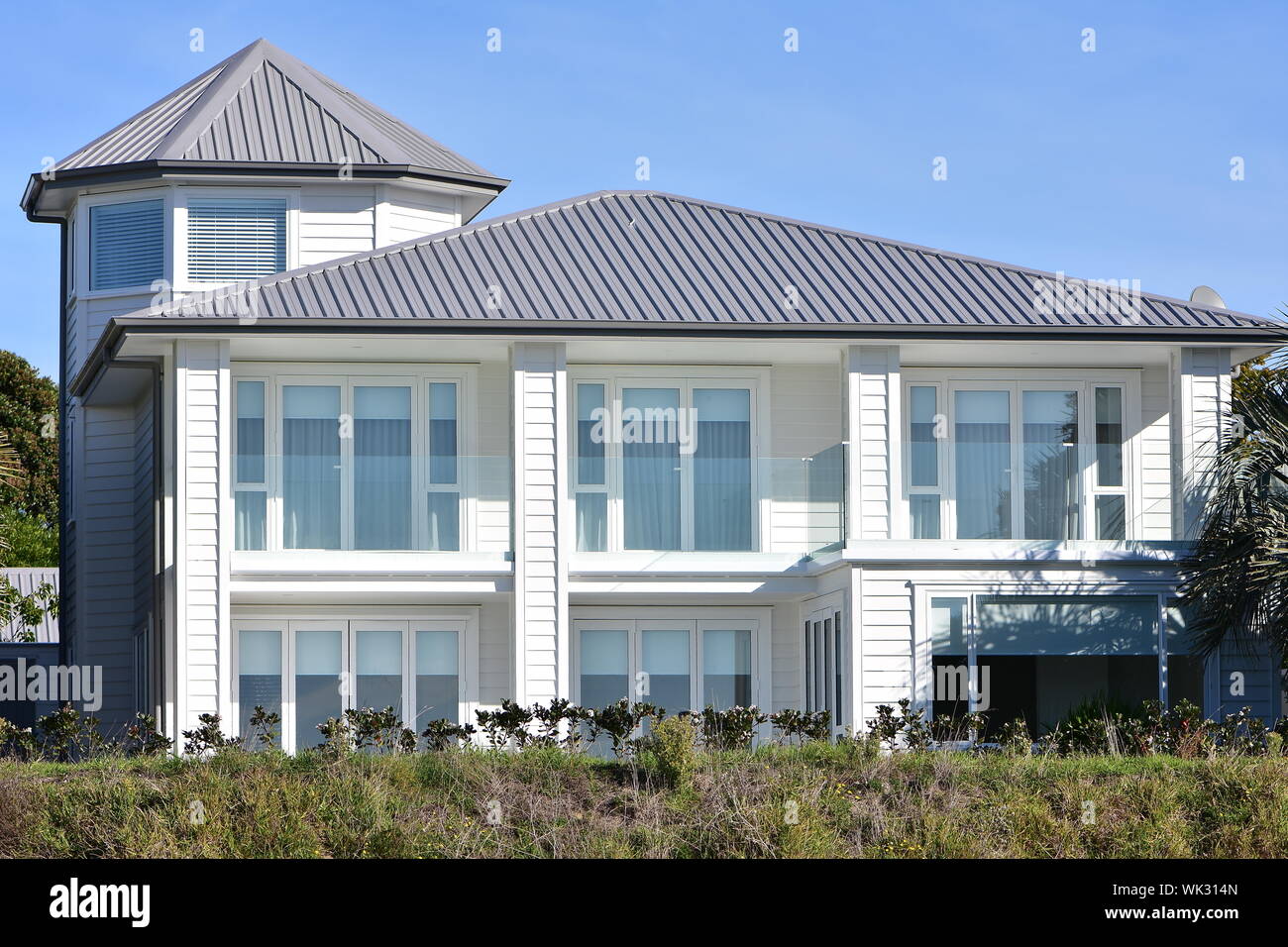 Grande maison en bois blanc de deux étages, avec des murs en verre pour la  plupart sur façade et tour à gauche Photo Stock - Alamy