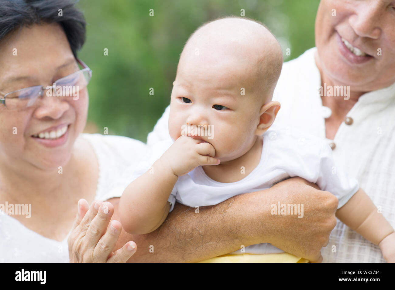 Les grands-parents d'Asie à jouer avec petit-enfant bébé au jardin extérieur. Banque D'Images