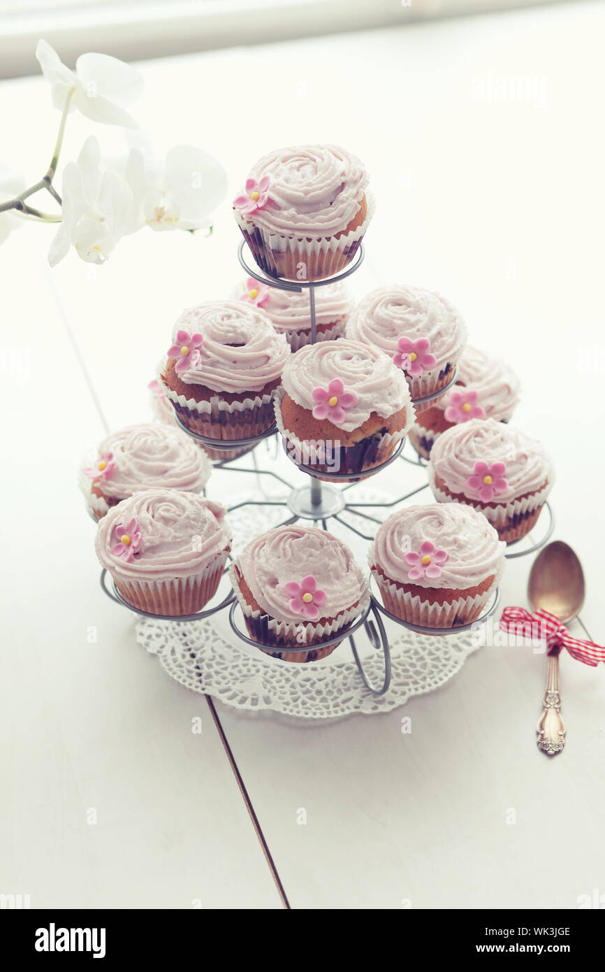 Cupcakes cupcake rose sur socle sur fond de bois Photo Stock - Alamy
