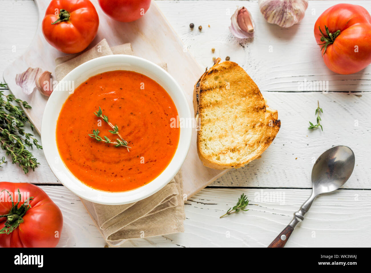 Soupe de tomate avec sandwich au fromage, vue du dessus, copiez l'espace. Soupe aux tomates maison avec le thym. Banque D'Images
