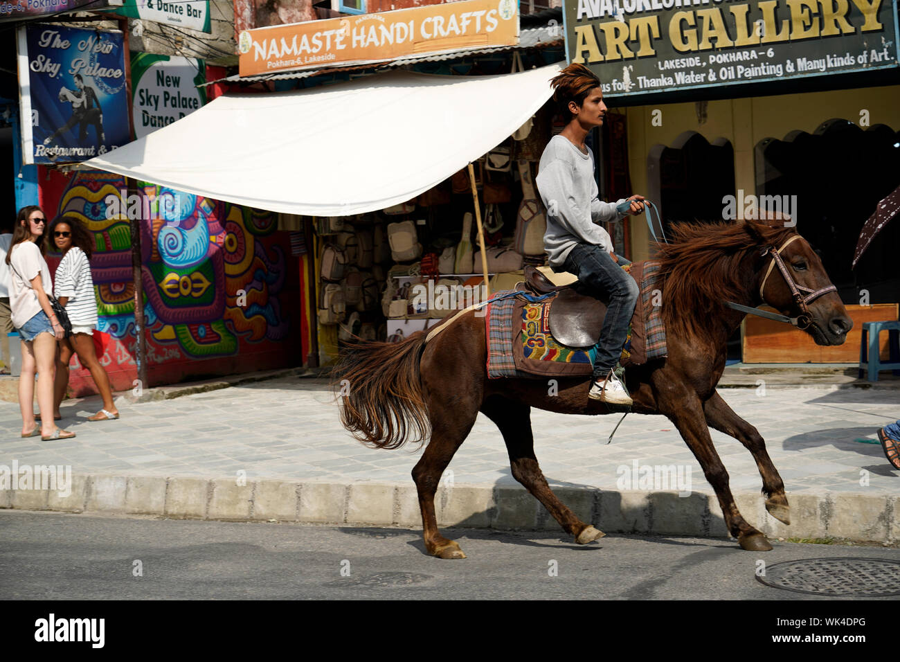 Homme à cheval à travers la ville de Pokhara au Népal Asie du Sud Banque D'Images