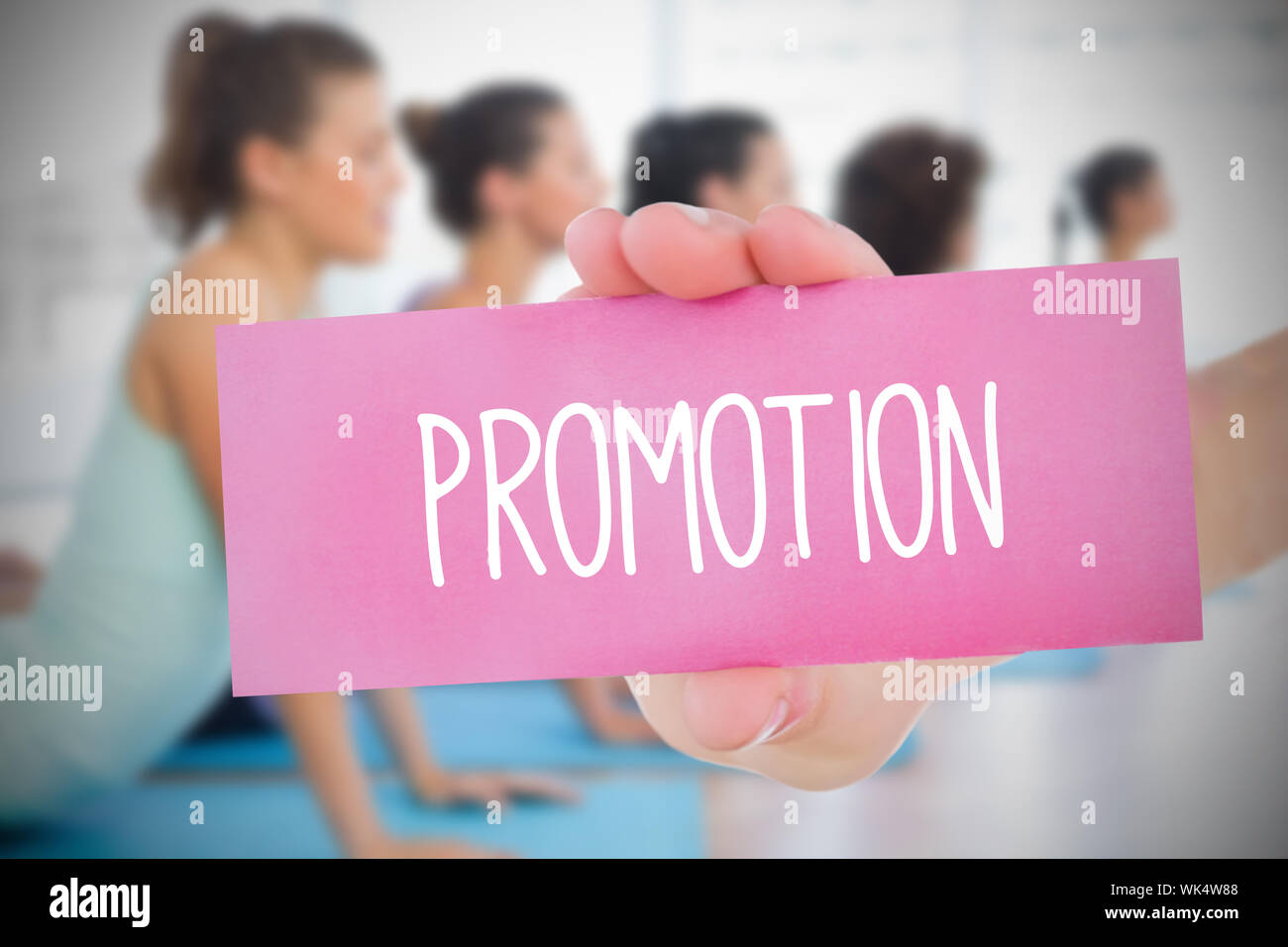 Woman holding carte rose disant promotion contre yoga class in gym Banque D'Images