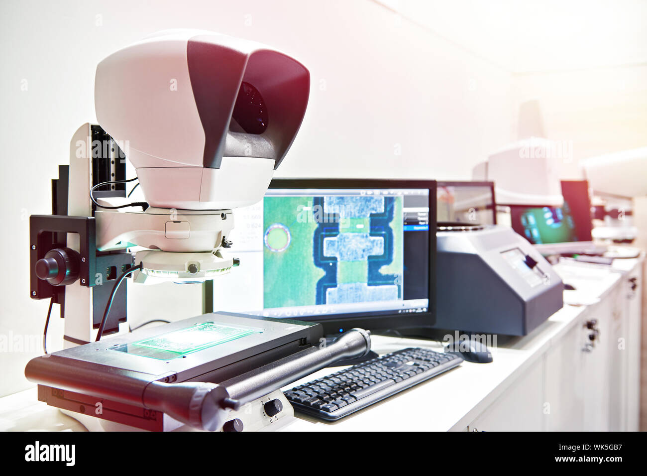 Avec moniteur au microscope de mesure dans la fabrication de pièces de contrôle Banque D'Images