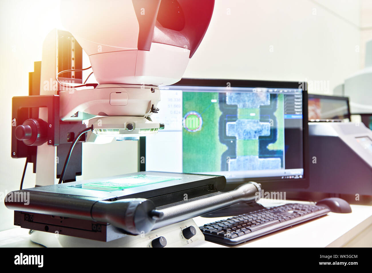 Avec moniteur au microscope de mesure dans la fabrication de pièces de contrôle Banque D'Images