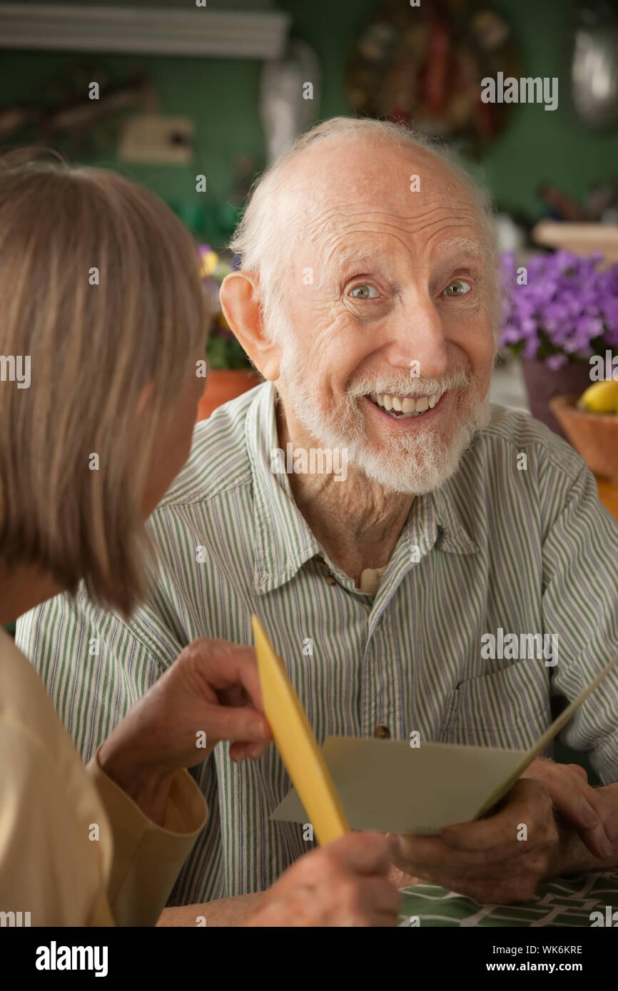 Senior man at home reading carte de souhaits avec femme Banque D'Images
