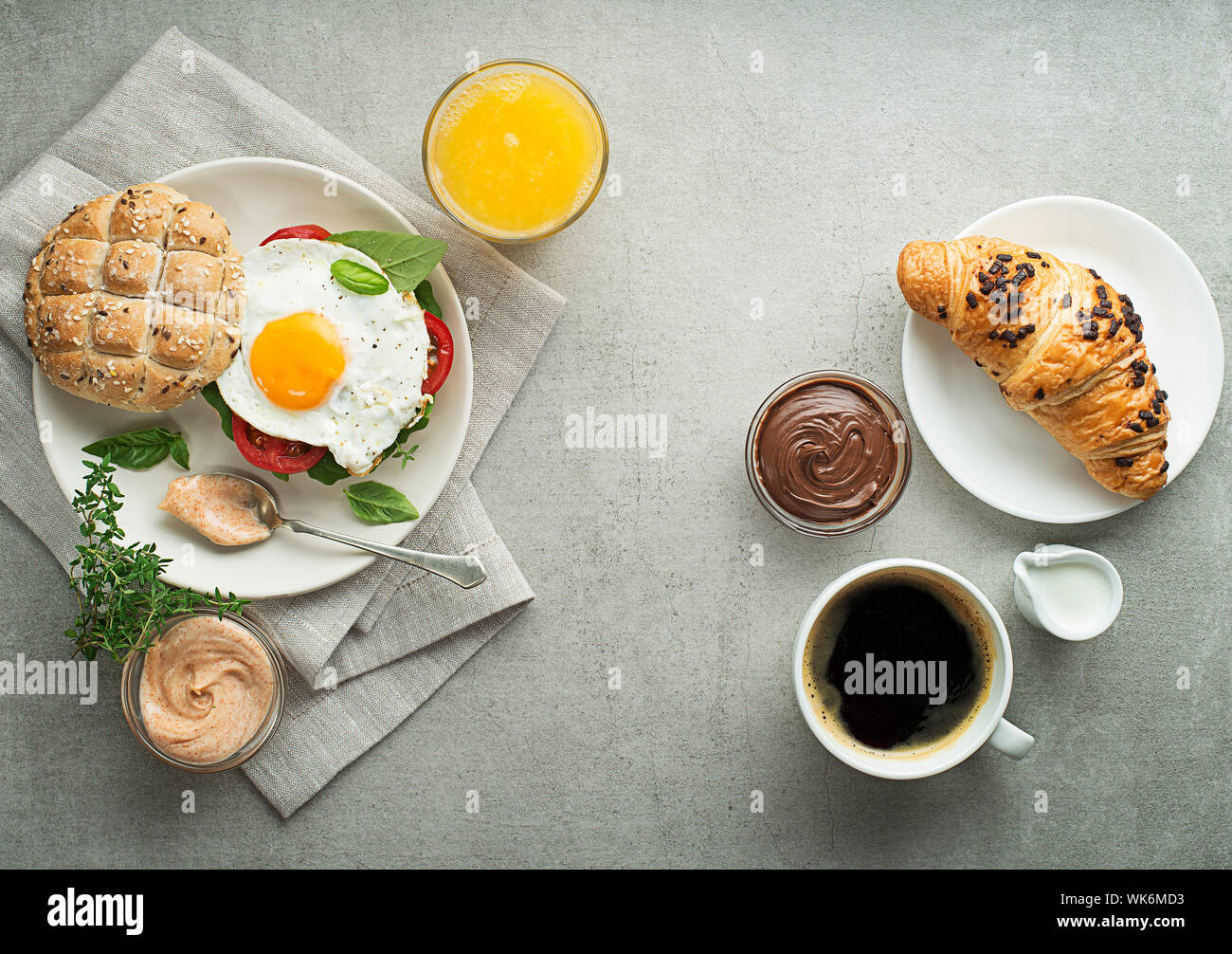 Petit-déjeuner servi avec du jus d'orange, un sandwich avec des œufs, des croissants et du café. Délicieux petit déjeuner sain. Banque D'Images