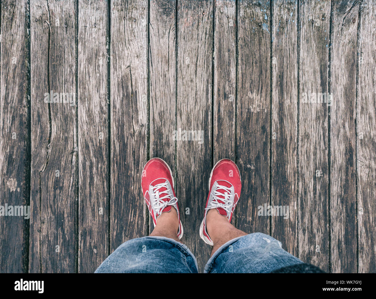 Pieds de sneakers sur un plancher en bois. Banque D'Images