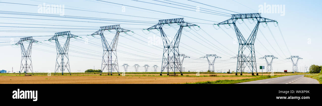 Vue panoramique sur une rangée de pylônes électriques dans la campagne française avec des dizaines d'autres pylônes au loin sous un ciel bleu clair. Banque D'Images