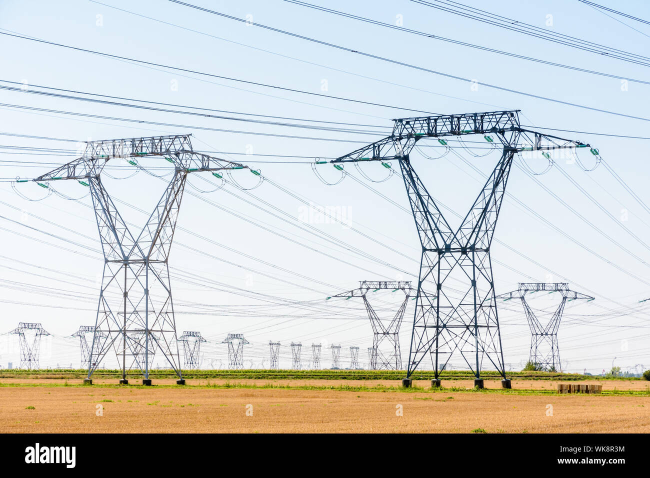 Des dizaines de pylônes électriques dans la campagne française sous un ciel bleu clair. Banque D'Images