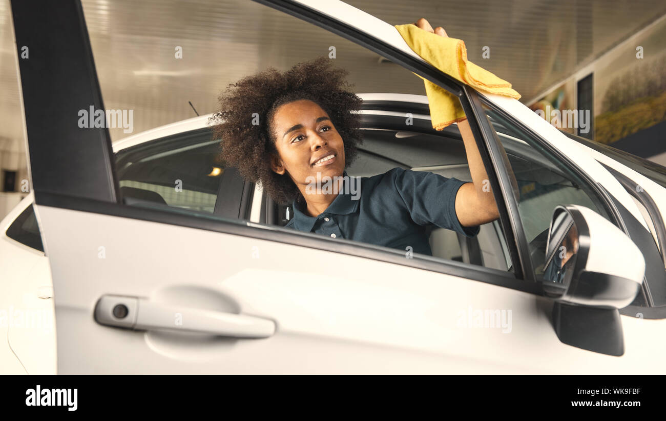 Femme africaine est le polissage de voiture avec porte serviette en concession Banque D'Images