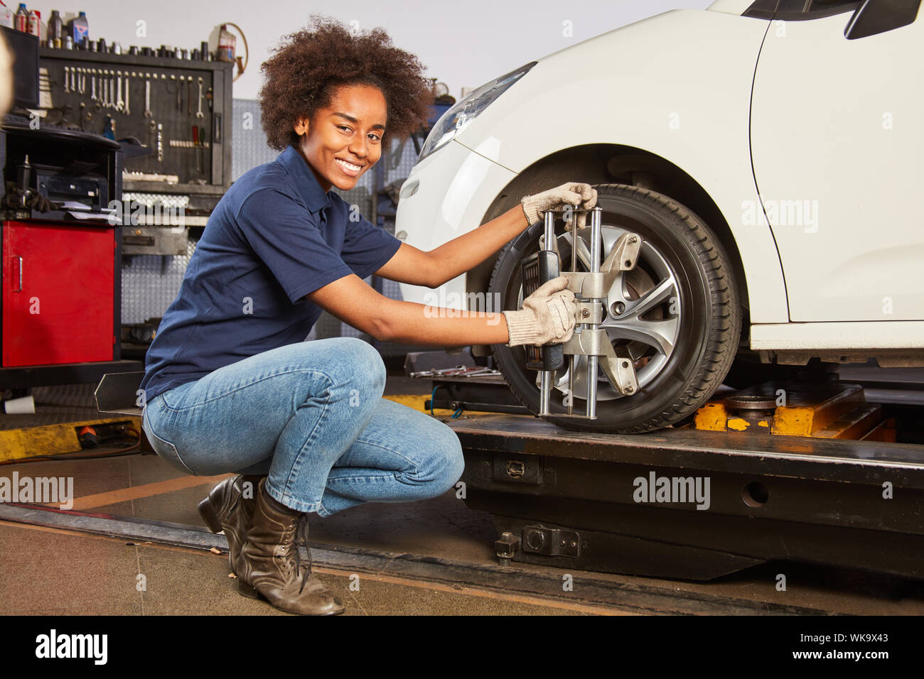 Femme africaine en tant qu'apprenti mécatronique fait un alignement de roue sur le train d'atterrissage Banque D'Images