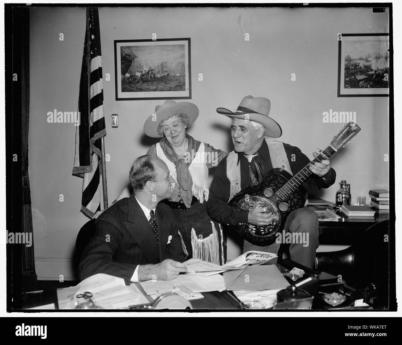 James Roosevelt 30ème anniversaire de la sérénade sur Washington, D.C., le 23 décembre. Arriver à sa 30e étape importante aujourd'hui, James Roosevelt a été bercé à la Maison Blanche par Jack Lee Powder River de Deer Lodge, au Montana, et sa femme, Kitty Lee. Bien que Lee grattées sa guitare à la hauteur de faire des noeuds dans la queue du diable, Mme Lee sang l'accompagnement, le 23/12/37 Banque D'Images