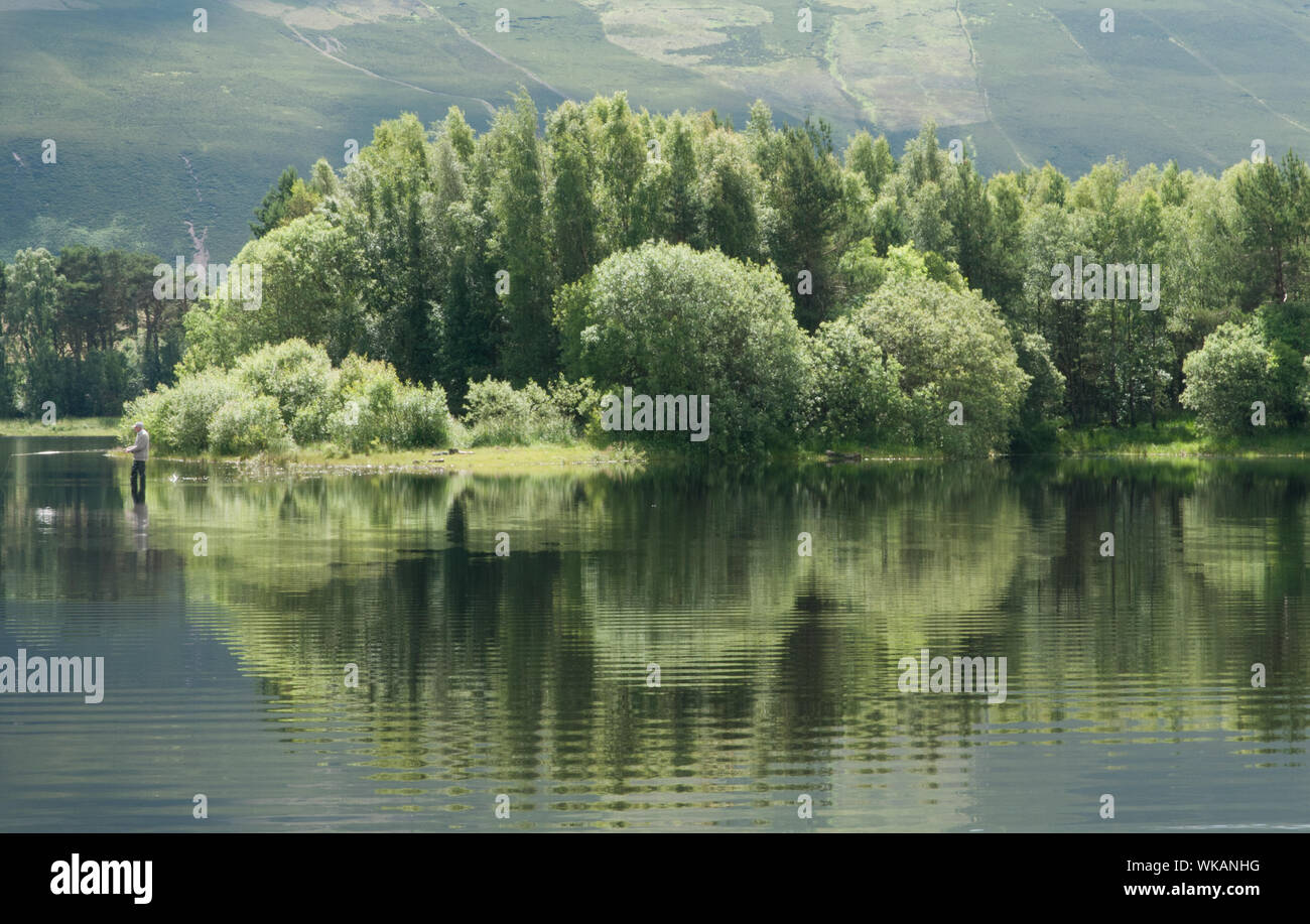 Pêcheur et réflexions Harlaw Réservoir et Pentland Hills Balerno Midlothian Ecosse Banque D'Images