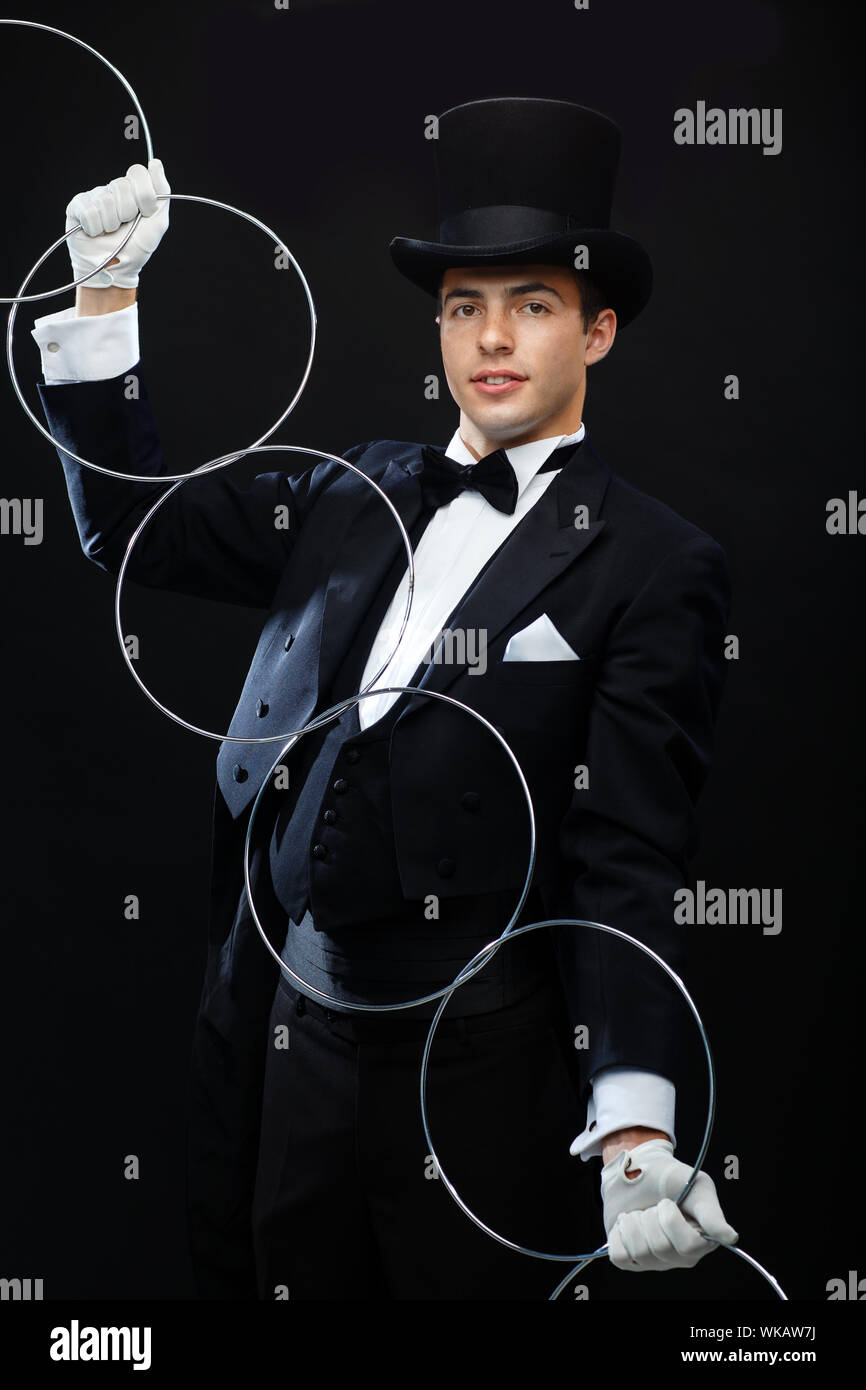 Magic, performances, cirque, show concept - Magicien dans top hat trick avec anneaux reliant montrant Banque D'Images