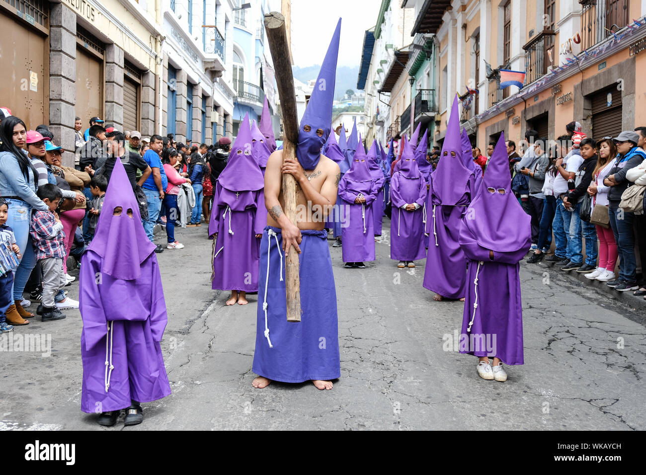 Les cucuruchos de l'Equateur à pied les rues historiques de Quito dans leurs robes pourpres et colorées cônes iconique le matin du vendredi saint. La procédure Banque D'Images