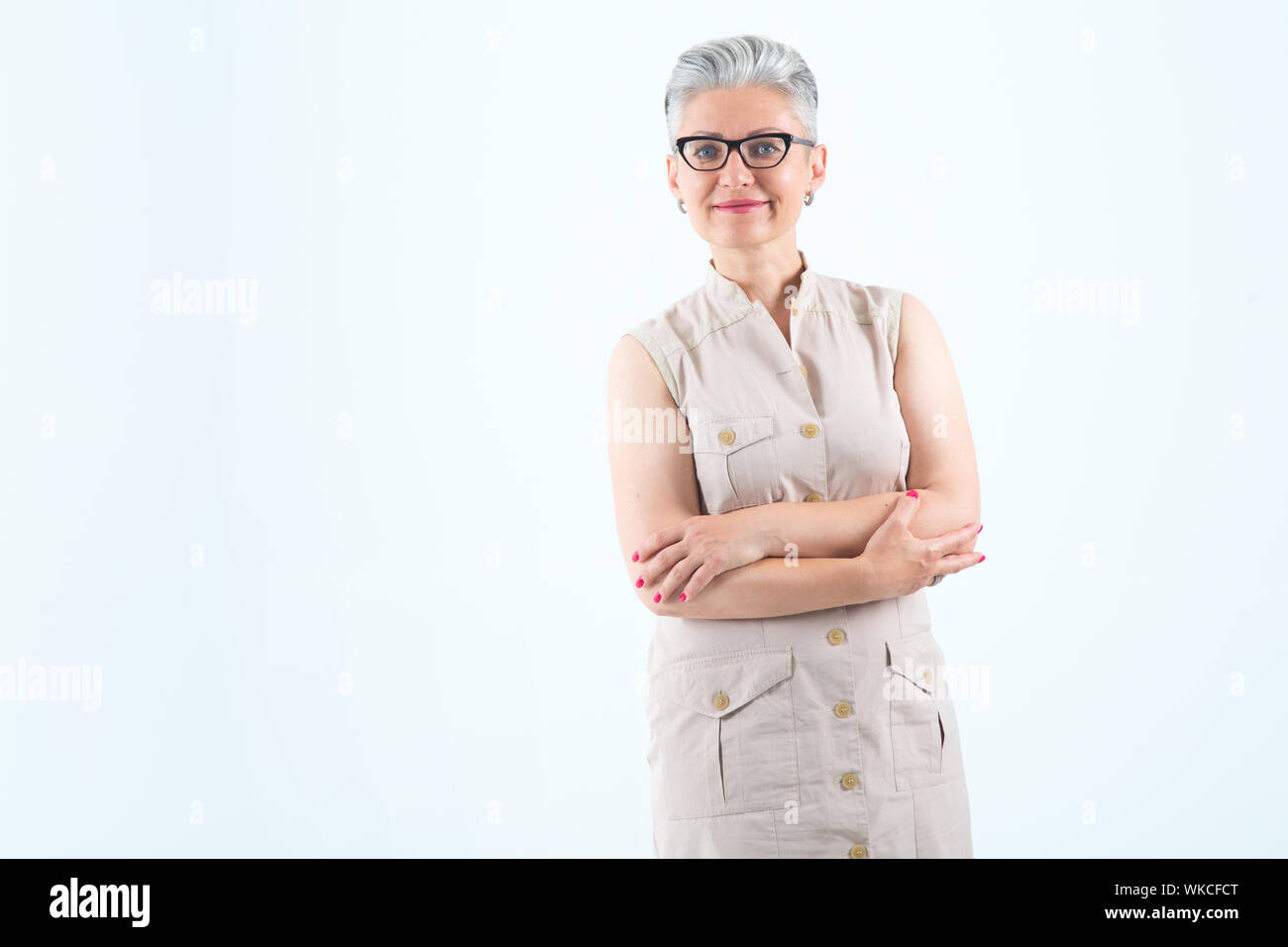 Belle femme mature à lunettes sur un fond bleu clair. L'âge moyen des femmes avec les cheveux gris. Banque D'Images