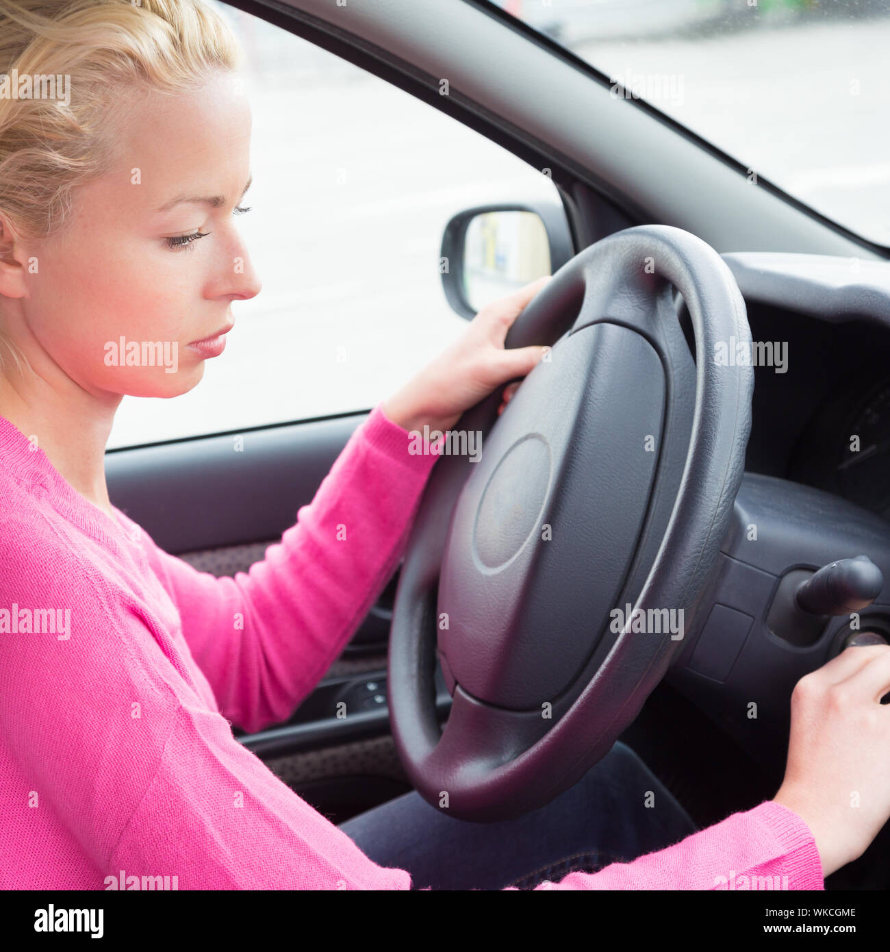 Belle femme vêtue à la légère voiture chauffeur de démarrer le moteur. Banque D'Images
