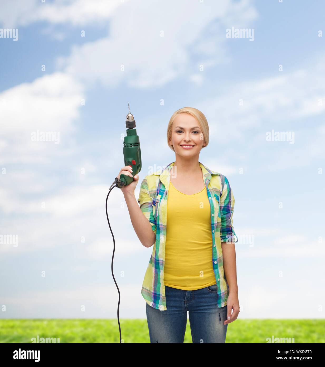 Femme souriante avec perceuse Banque D'Images
