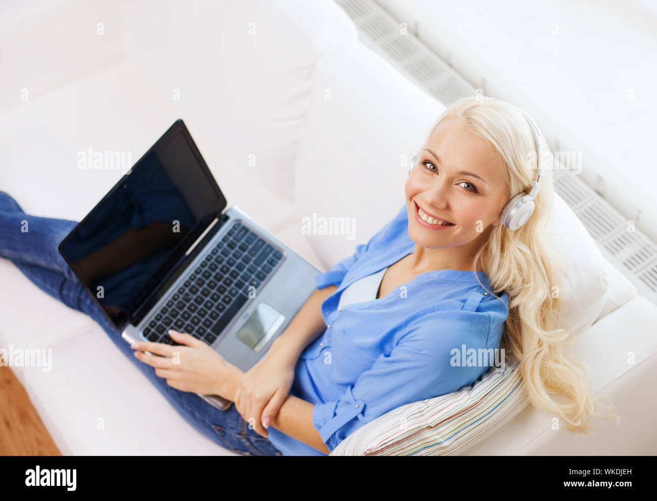Femme avec un ordinateur portable et un casque à la maison Banque D'Images