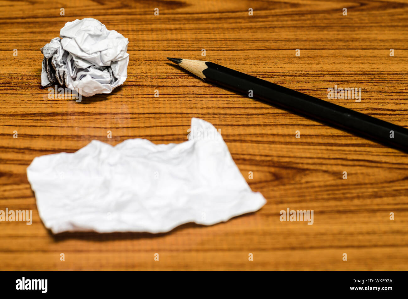 Rebuts de papier froissé et au crayon sur fond de bois Banque D'Images