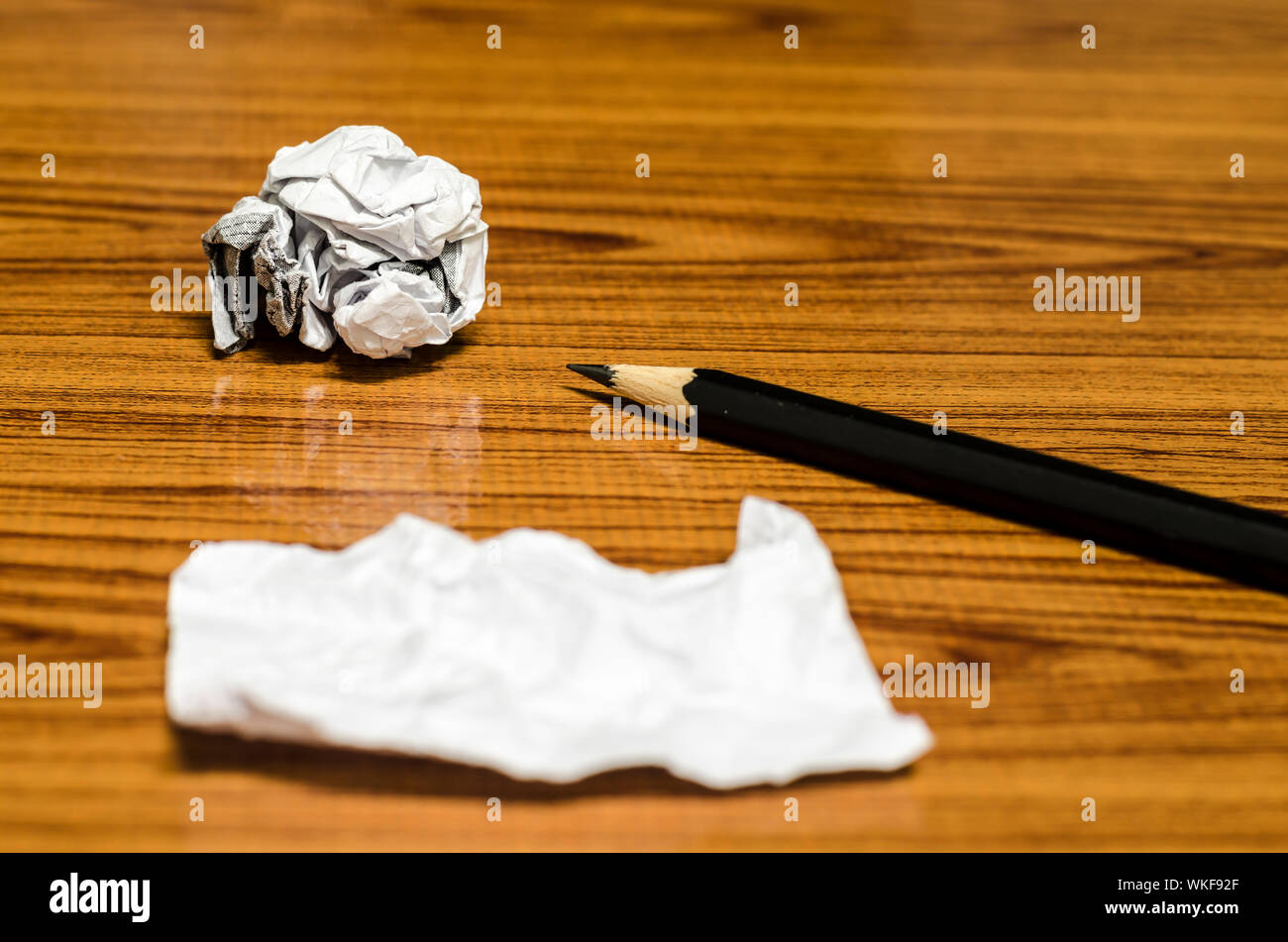 Rebuts de papier froissé et au crayon sur fond de bois Banque D'Images