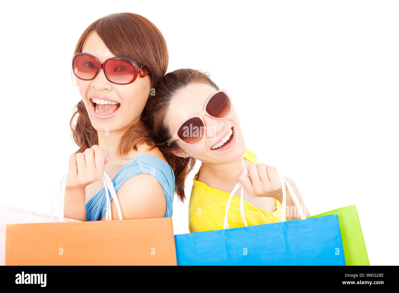 Les jeunes sœurs holding shopping bags et dos à dos Banque D'Images