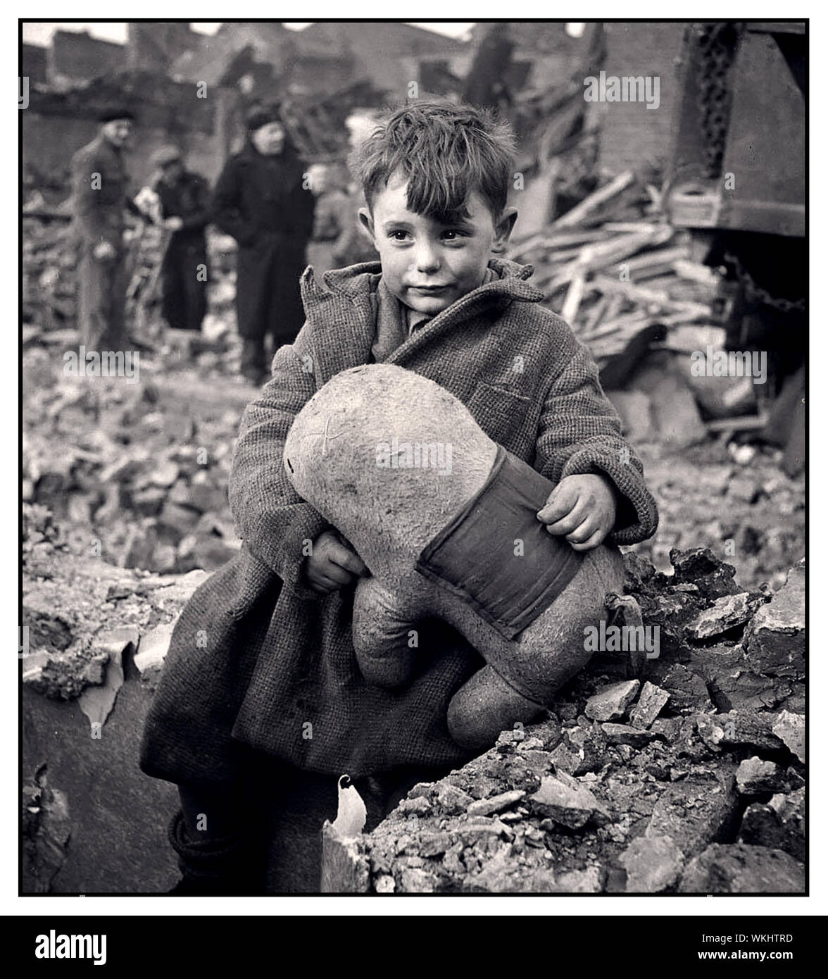 WW2 propagande britannique de droit d'un timide garçon tenant un animal en peluche au milieu de ruines après un bombardement aérien allemand de Londres, 1940 Banque D'Images
