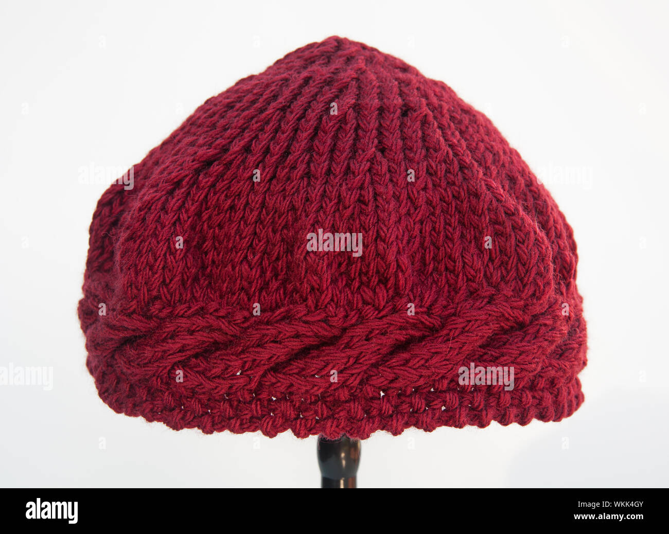 Vin de Bourgogne Knit hat isolé sur fond blanc. Cette fibre est faite de fil de laine de couleur marron profond avec câble de suture autour du bord sont Banque D'Images