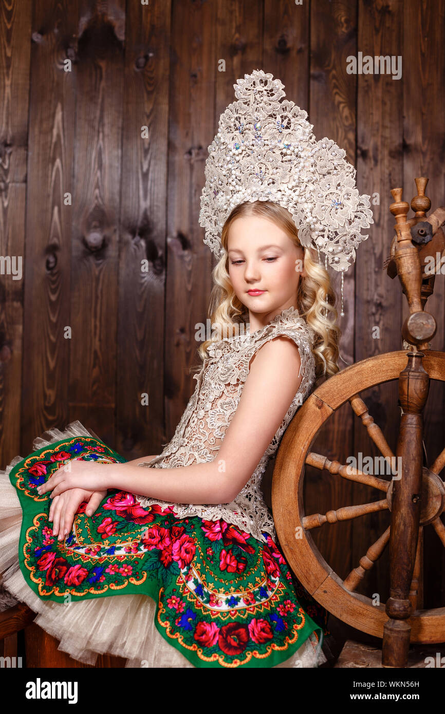 Jeune fille russe dans une robe russe folklorique sur fond de bois avec  roue tournante Photo Stock - Alamy