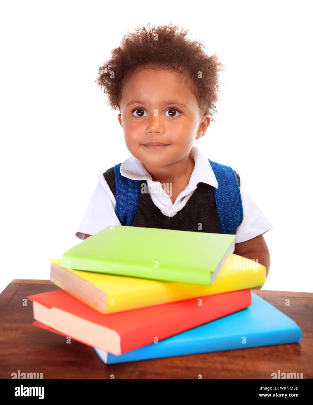Portrait of cute little boy wearing school uniform avec de nombreux livres colorés isolé sur fond blanc, faire ses devoirs, concept retour à l'école Banque D'Images