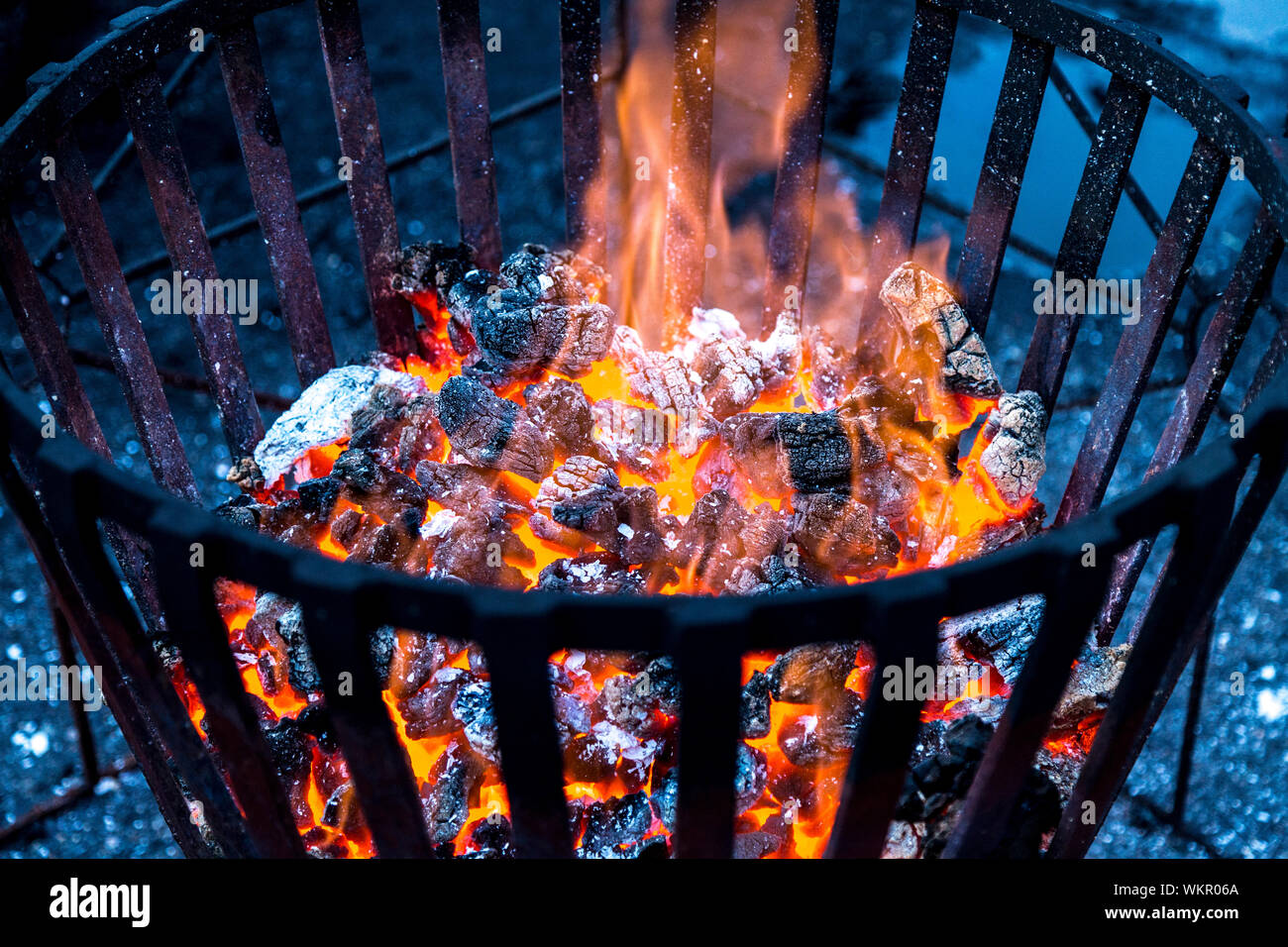 Un feu brûlant chaud charbons dans un panier de feu métallique Banque D'Images