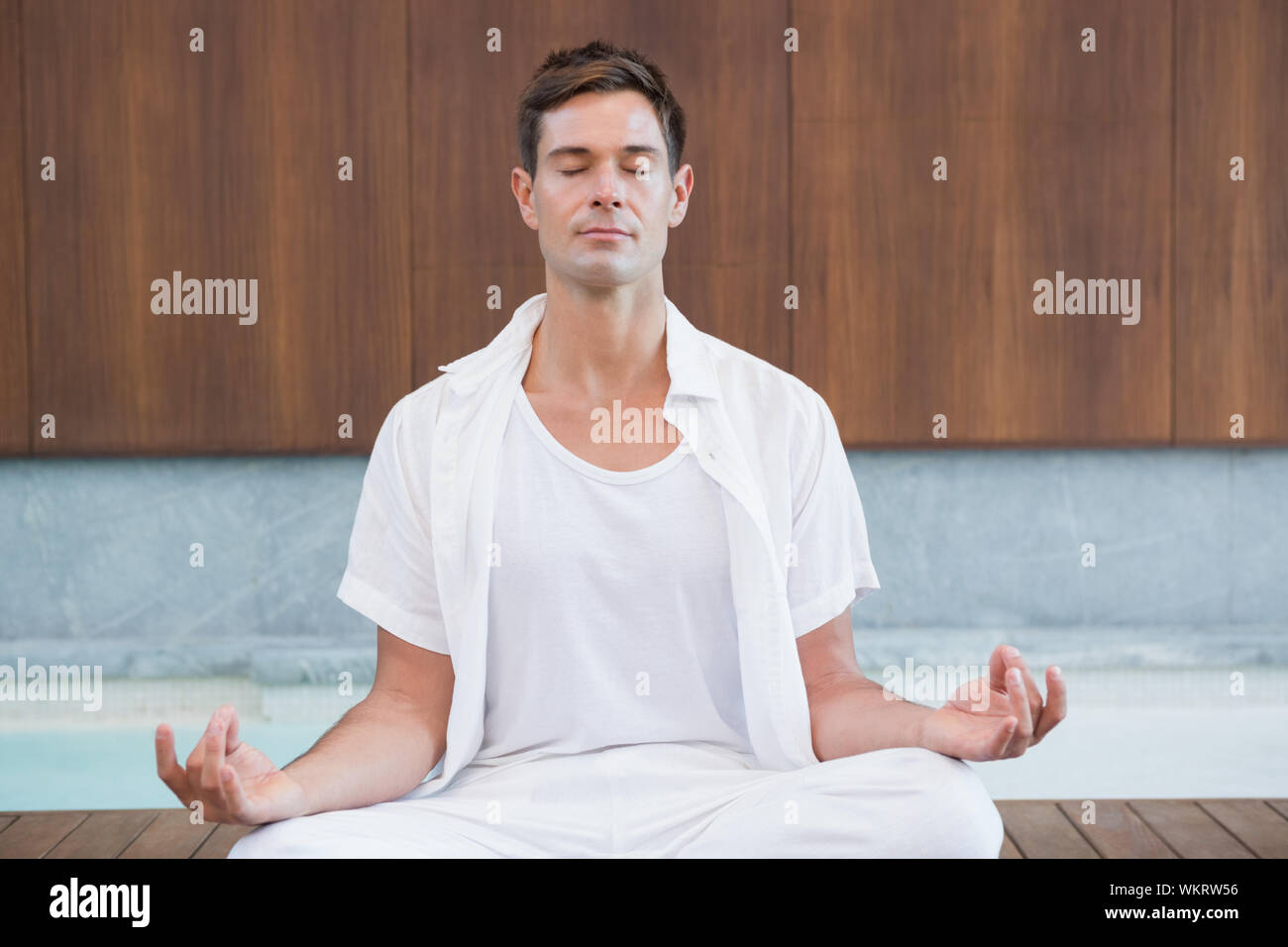 Bel homme blanc en méditant dans lotus poser dans health spa Banque D'Images