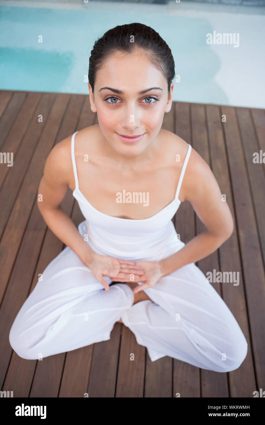 Brunette pacifiques en blanc assis en lotus de poser dans les health spa Banque D'Images