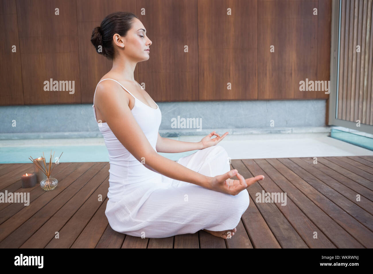 Brunette pacifiques en blanc assis en lotus de poser dans les health spa Banque D'Images
