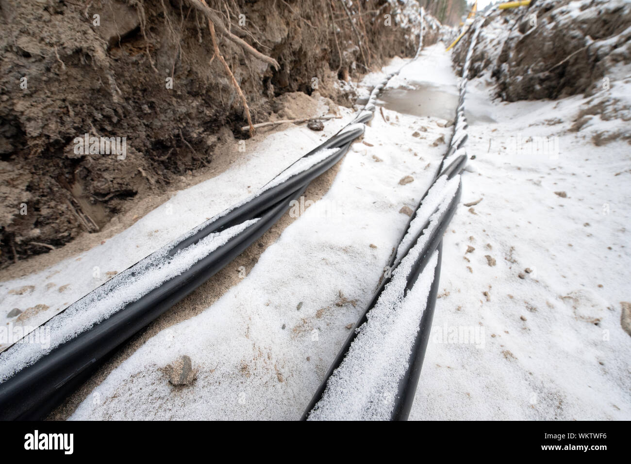 La pose d'une fibre optique et les câbles de l'électricité dans le sol gelé, câbles enterrés pour un accès internet rapide en région rurale - câbles souterrains en Finlande Banque D'Images