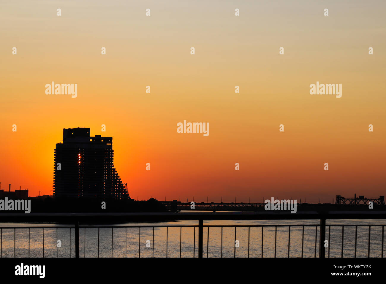 Silhouette d'un gratte-ciel et pont sur un fond coucher de soleil, sur la rivière dans une ville, Dnepropetrovsk, Ukraine, Ukraine. Banque D'Images