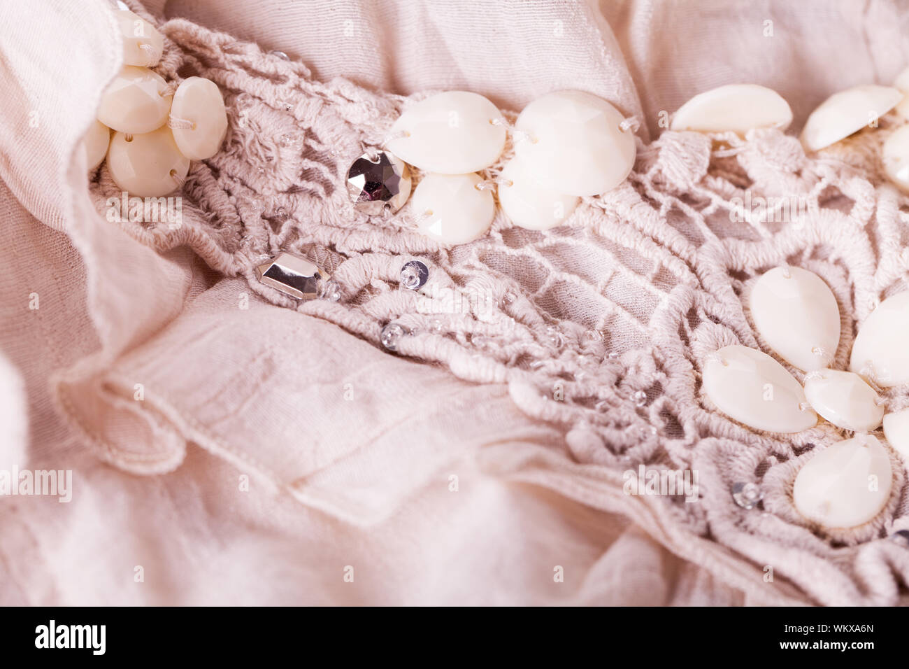 Close up detail de broderie florale sur un vêtement rouched recueillies avec une gerbe de fleurs et de bourgeons et de détail en dentelle Banque D'Images