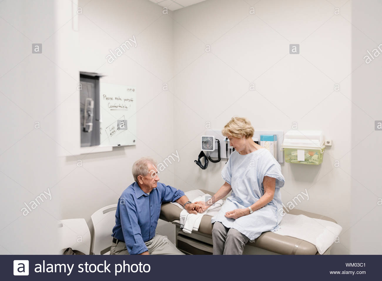 Caring man en attente avec femme en salle d'examen clinique Banque D'Images