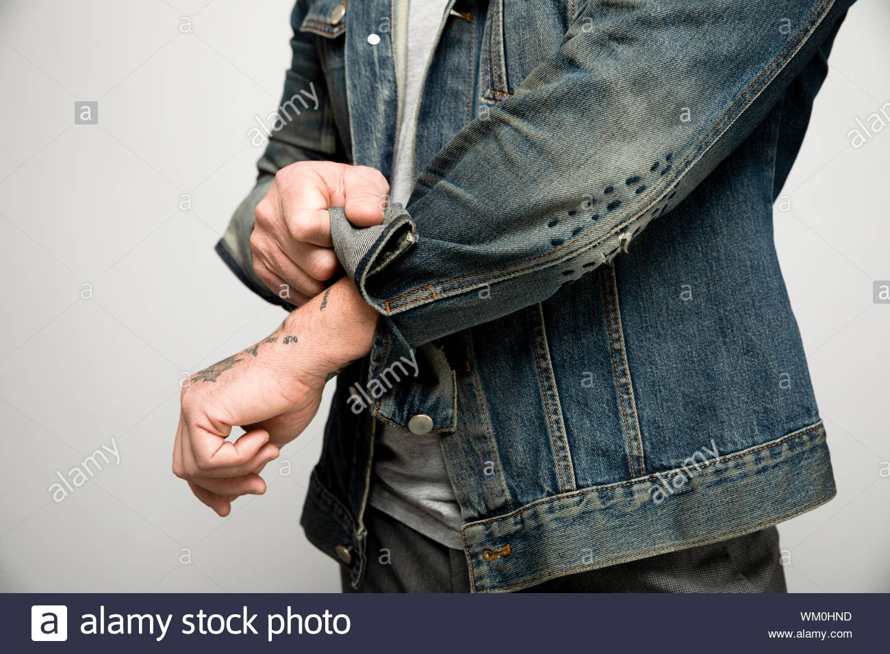 Close up man retrousser les manches de la veste en jean Photo Stock - Alamy