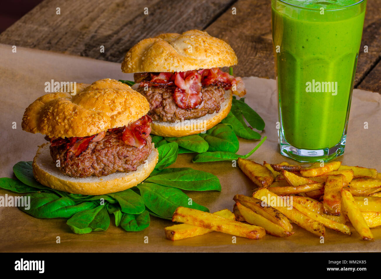 Bacon burger avec frites et herbes chili banana smoothie sur table en bois Banque D'Images Bacon burger avec frites et herbes chili banana smoothie sur table en bois Banque D'Images