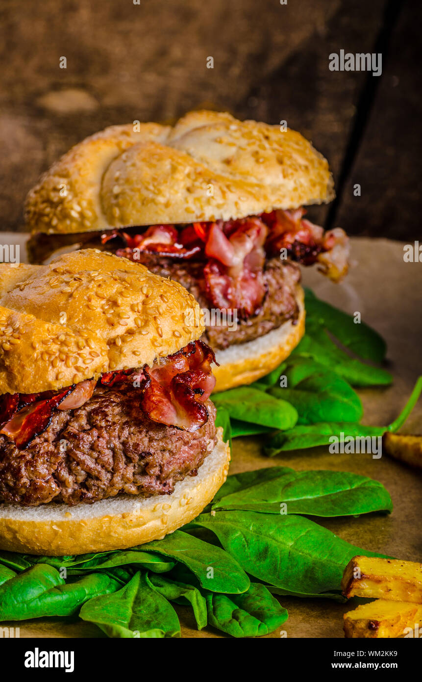 Bacon burger avec frites et herbes chili banana smoothie sur table en bois Banque D'Images